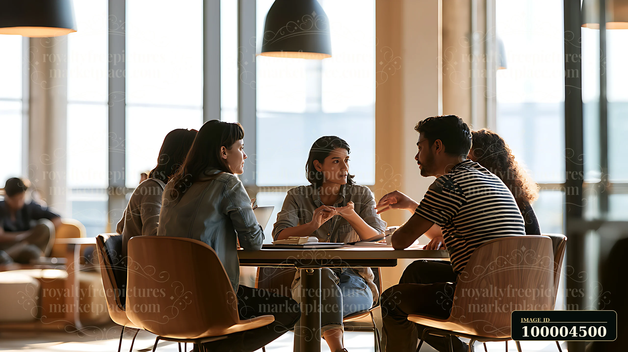 A group of people is discussing ideas around a table in a shared coworking space.