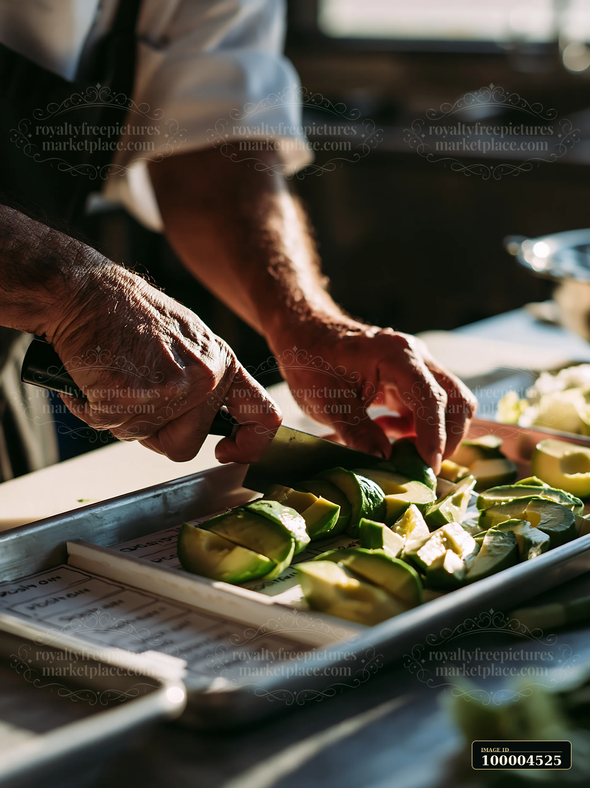 Hands are slicing avocado for sushi in a kitchen.