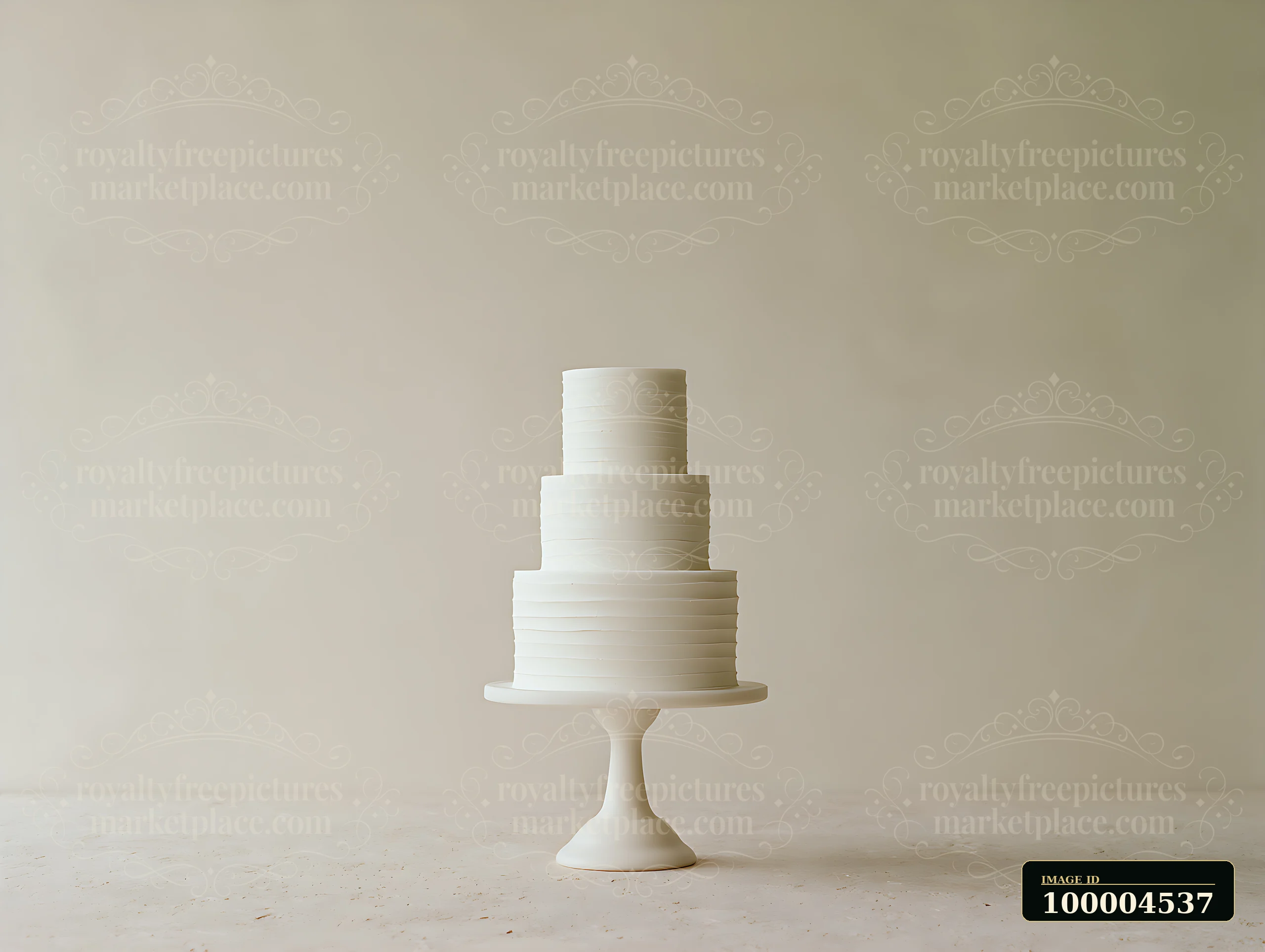 A three-tier minimalist wedding cake stands on a simple pedestal against a neutral background.