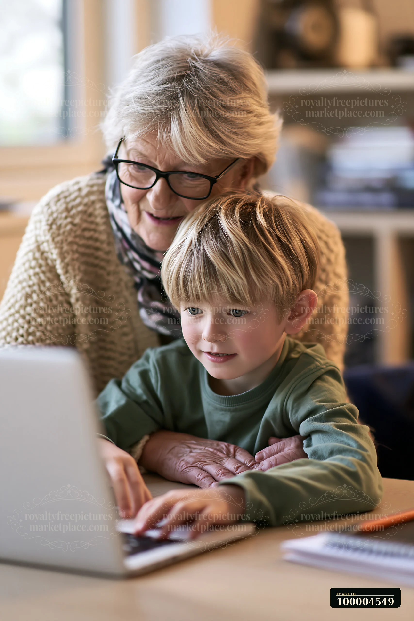 A grandmother assists her young grandson with tasks on a laptop.