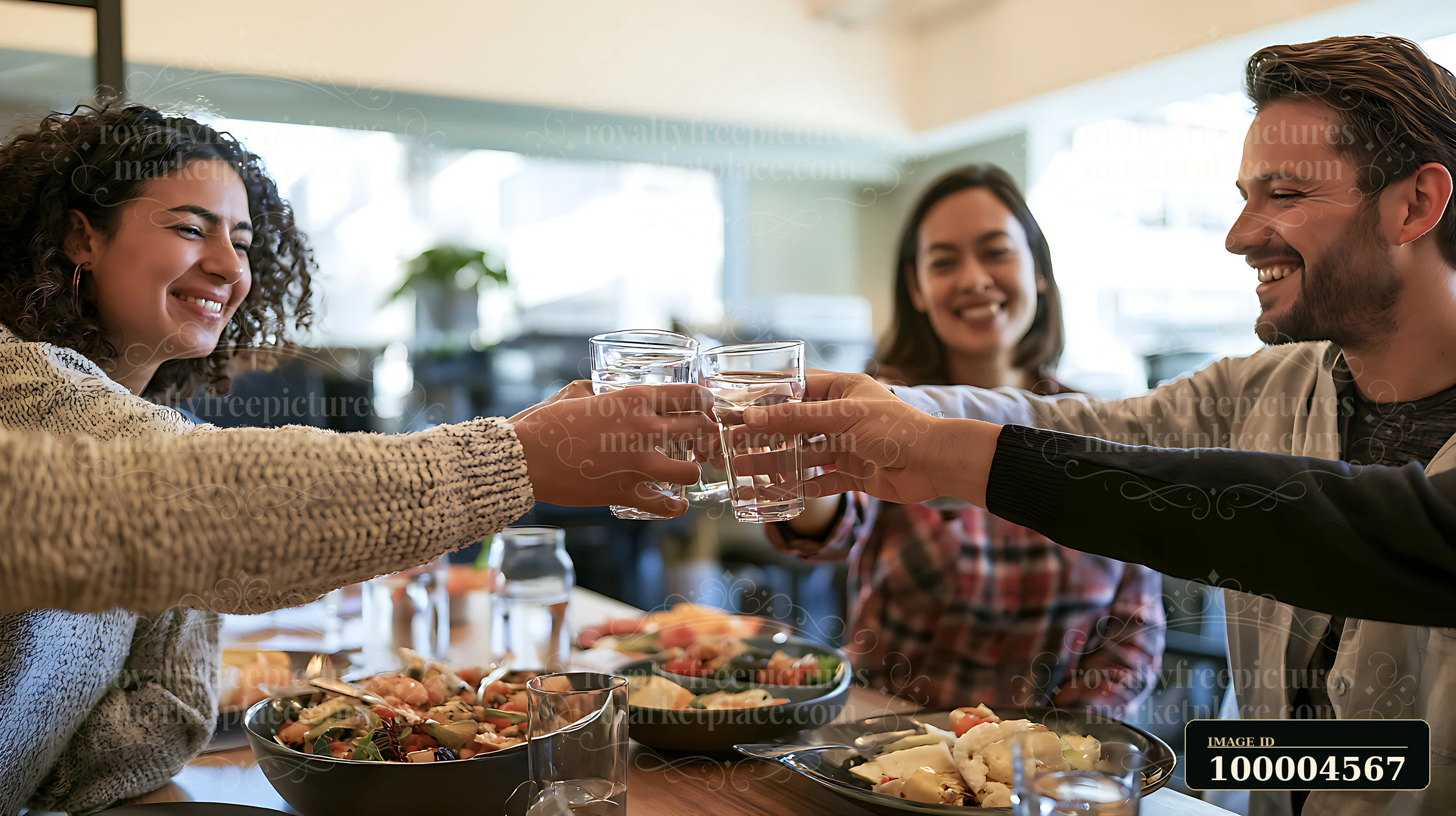Four coworkers share a toast during a casual office lunch buffet.