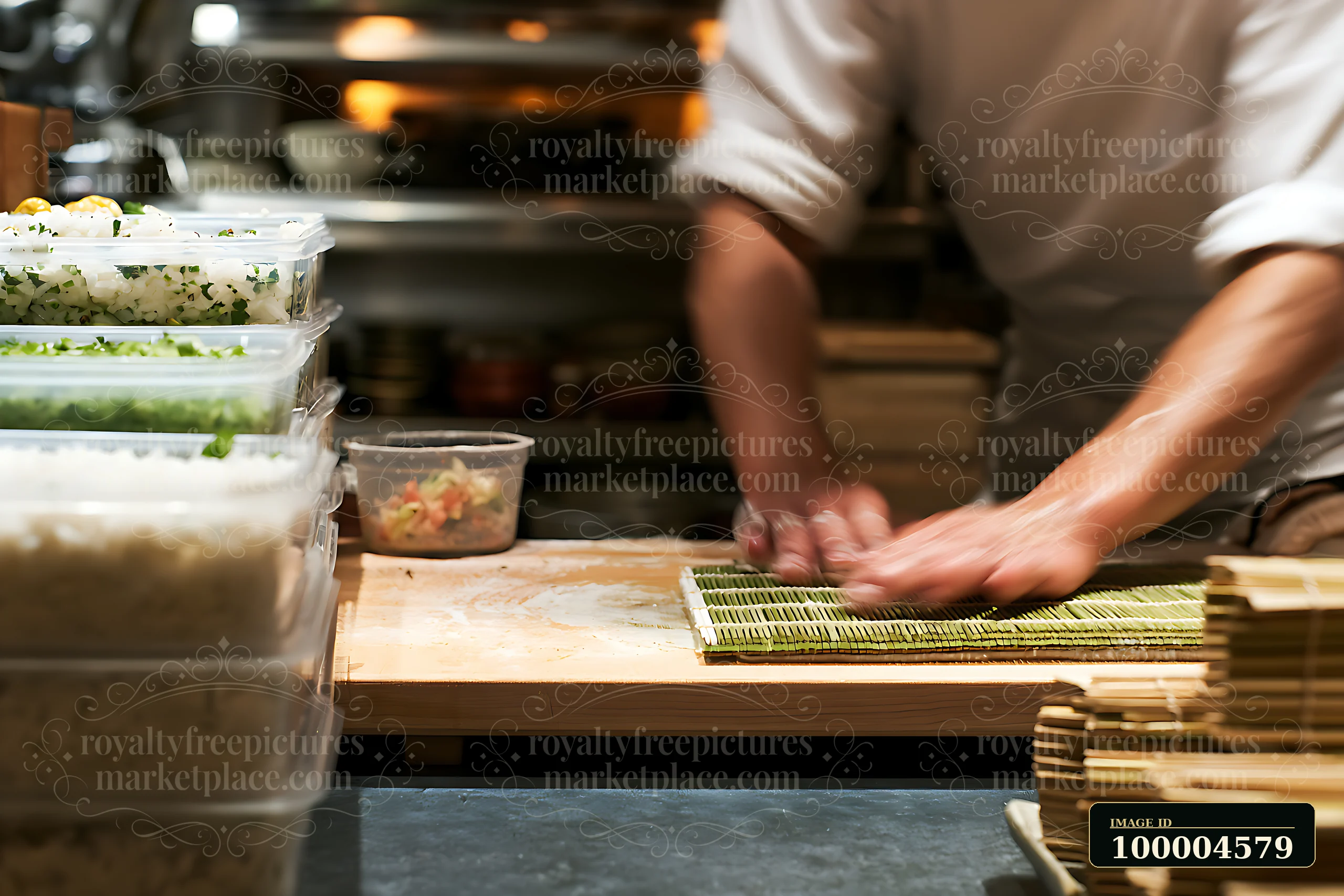 Sushi chef rolls maki on a bamboo mat at a preparation counter in a warmly lit kitchen.