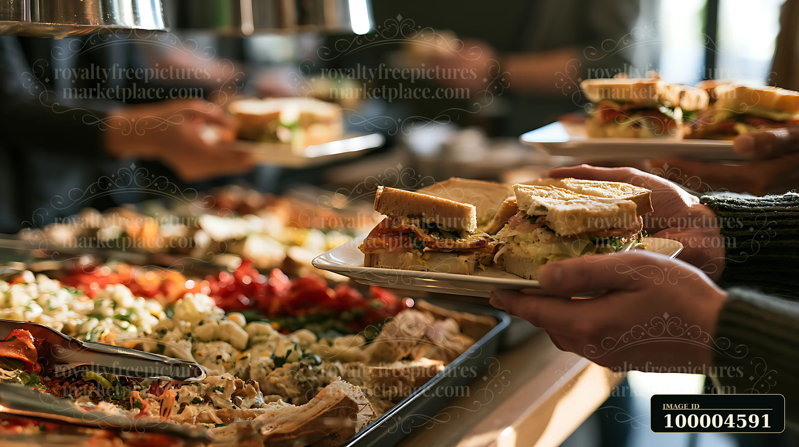 People serve sandwiches and salads from a buffet counter during a workplace lunch.