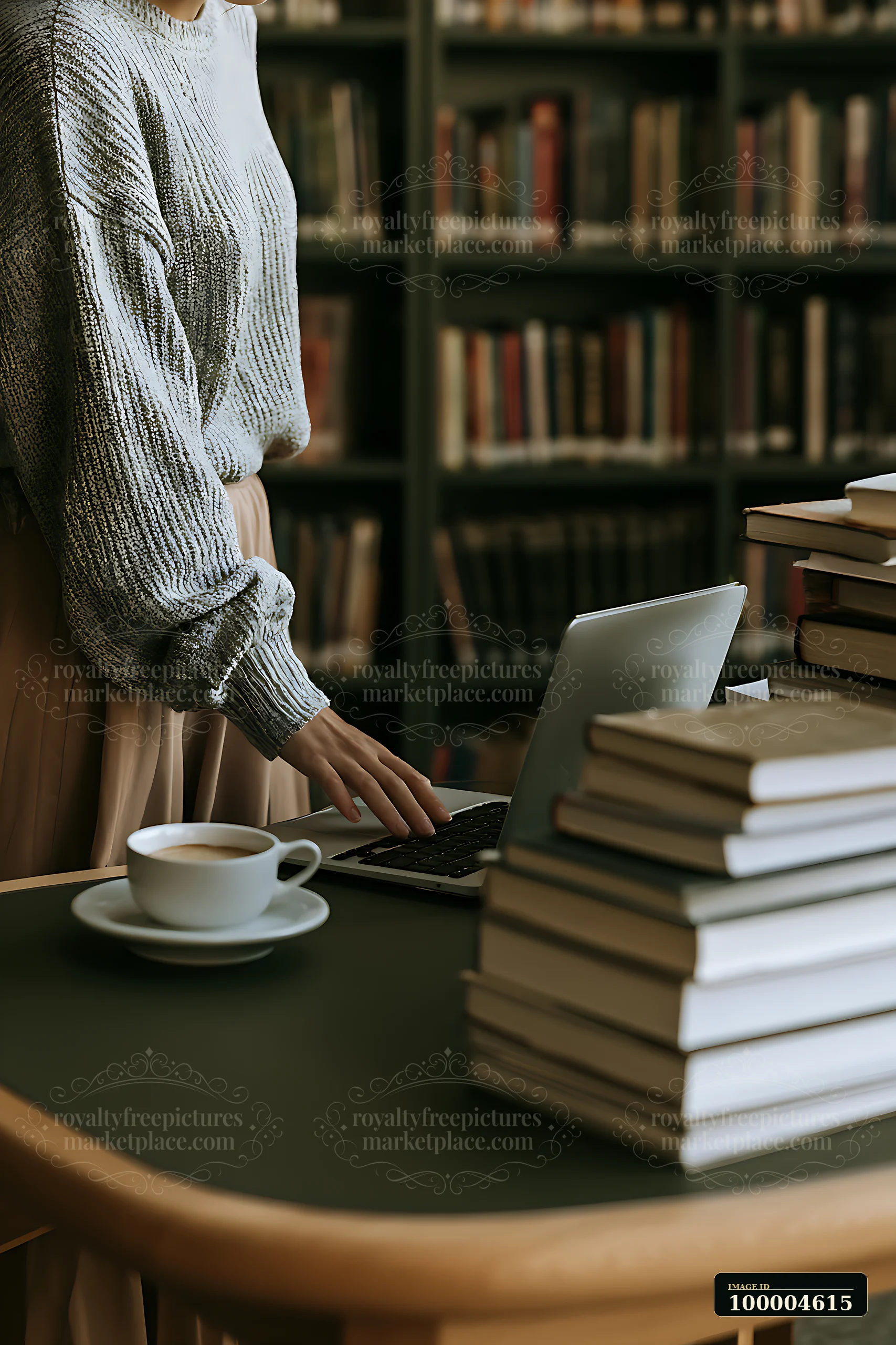 A businesswoman stands at a desk in a library, placing a laptop beside a cup of coffee.