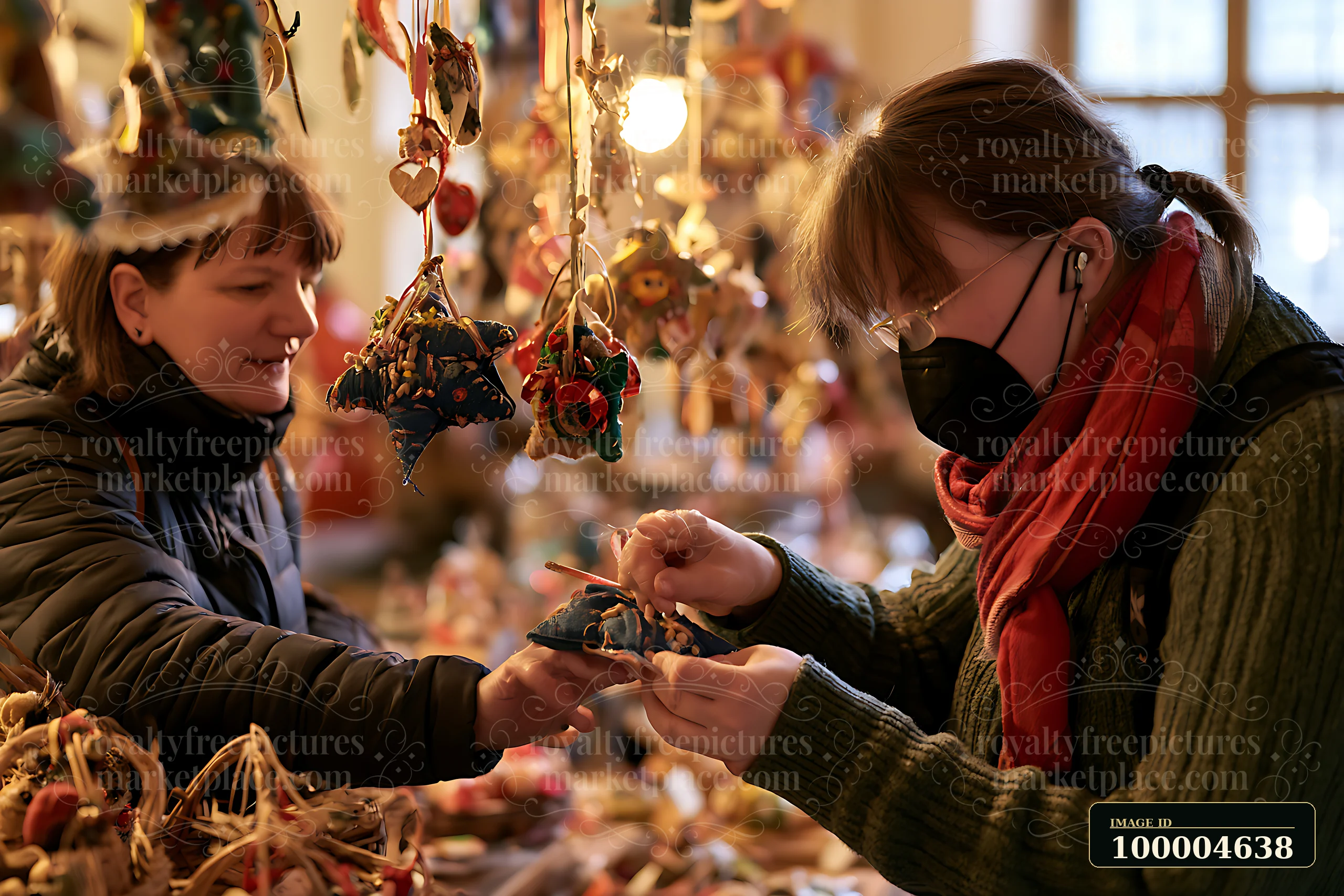 Two women interact at a market stall filled with handmade ornaments.