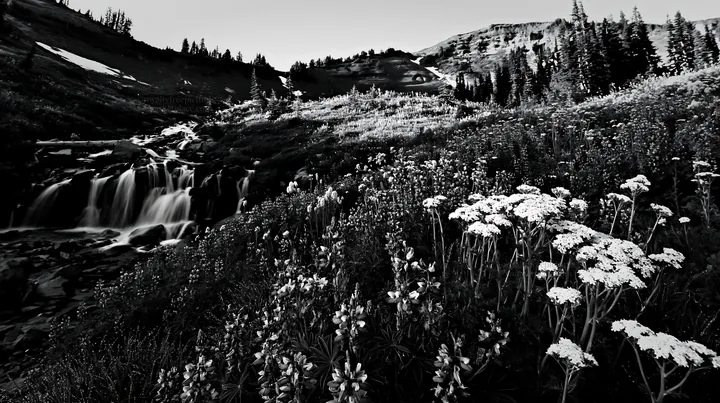 Mountain flower meadow with waterfall during daylight - AI-generated stock image