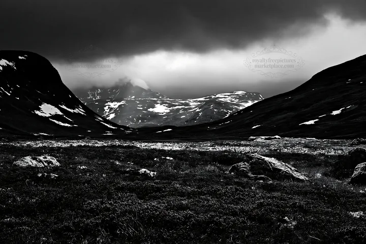 Sunbeams over Jotunheimen valley meadow with mountains - AI-generated stock image