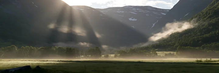 Meadow mountain sunrays illuminate a valley in morning light - AI-generated stock image