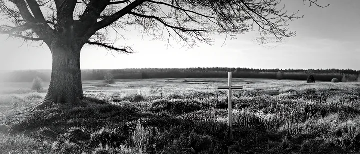 Christian cross in meadow with low light and winter scenery - AI-generated stock image