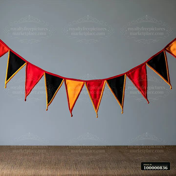 A garland made of triangular flags in red, black, and yellow hangs against a gray background.