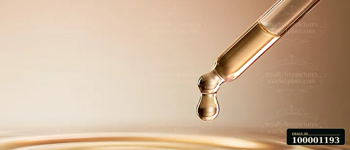 A dropper is releasing a clear drop of liquid onto a smooth surface, creating ripples.