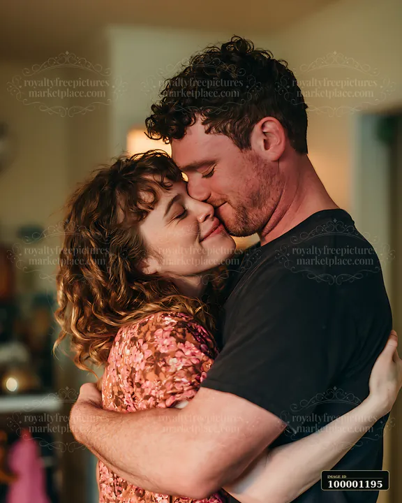 Two people embrace in a warm indoor setting.