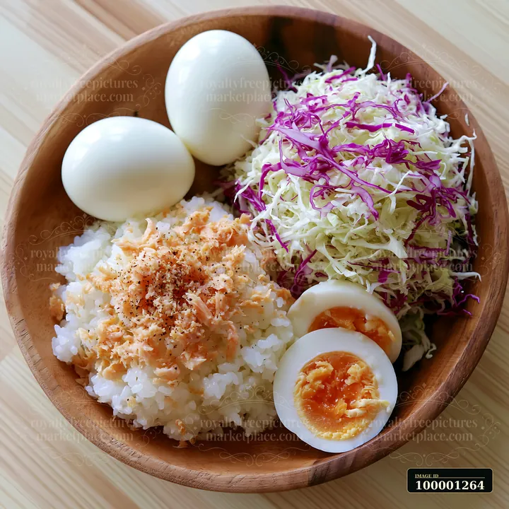A breakfast plate with Japanese breakfast features rice topped with fish flakes, boiled eggs, and shredded cabbage served in a wooden bowl.