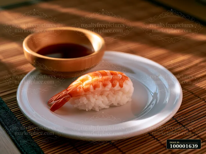 One shrimp sushi piece on a white plate sits beside a bowl of soy sauce.