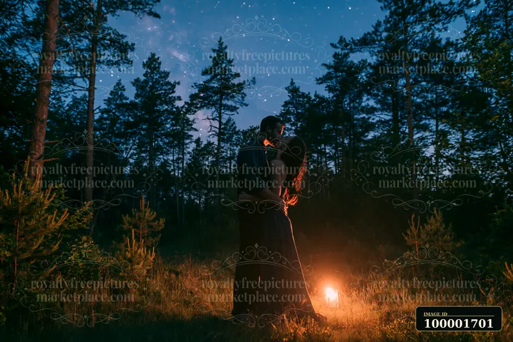 A couple kissing under stars in a forest clearing with trees surrounding them at night.