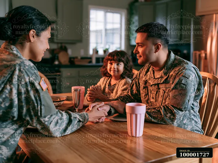A soldier greeting family shares a moment at the dining table after returning home.
