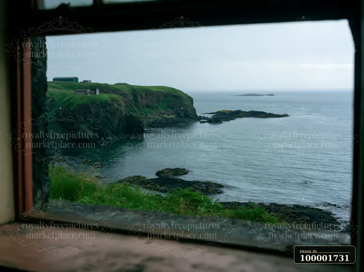 A coastline with rocky peninsula can be seen through the window.