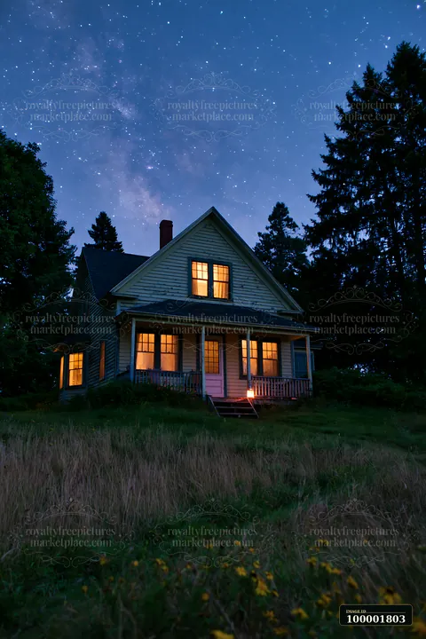 A country house stands in a grassy area, featuring bright windows that glow against the dark sky filled with stars.