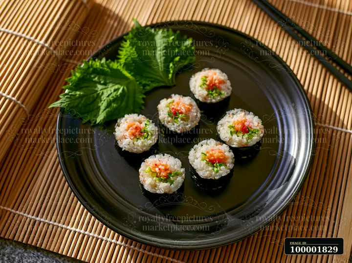 Sushi with shiso leaves is displayed on a black plate.