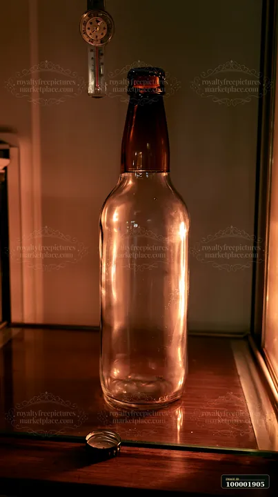 An empty bottle is placed on a wooden shelf inside a refrigerator.