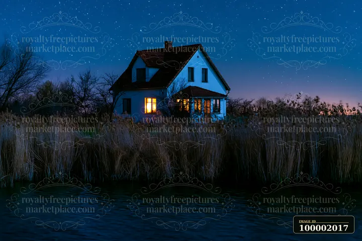 A house beside a starry lake stands with light shining from its window.