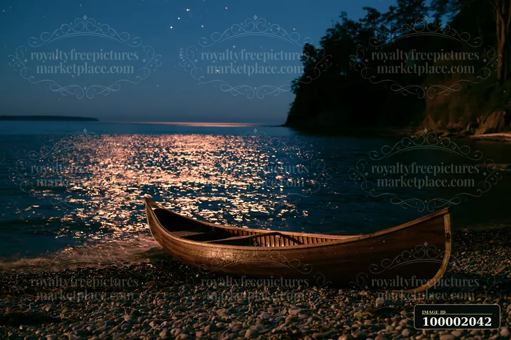 A canoe rests on a rocky beach under a starry night sky.