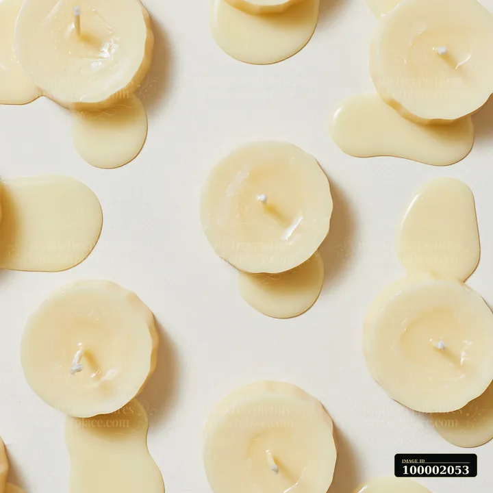 Several vanilla candles are placed on a neutral background.