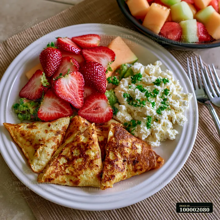 A breakfast plate features seasonal fruit alongside three golden pastries and cottage cheese.