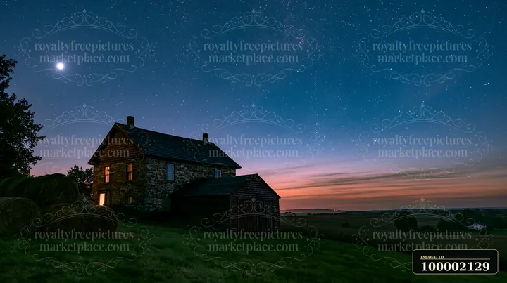 A farmhouse beneath night sky shows a clear view of stars and moon.