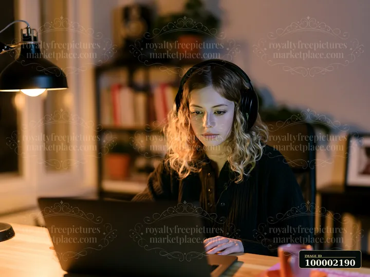 A woman works on a laptop at a desk in an office setting designed for accessibility.
