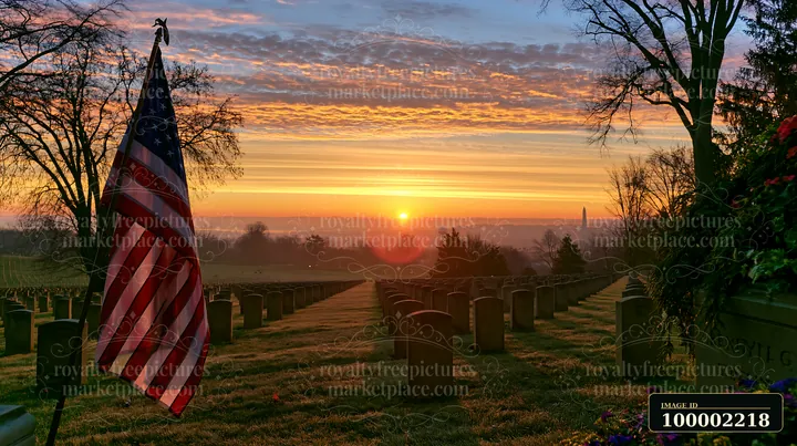 An American flag stands tall at Arlington cemetery as the sun rises, illuminating the landscape and highlighting the rows of headstones in the early morning lig