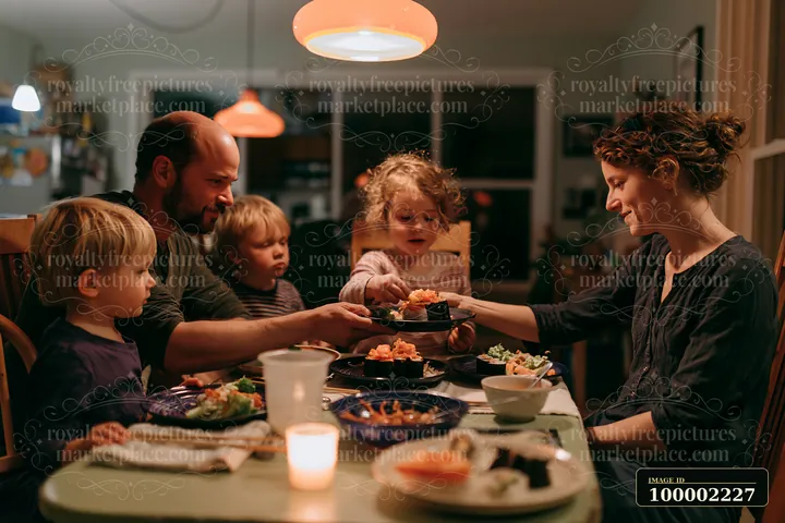 A family sharing sushi dinner includes two adults and three children seated around a table.