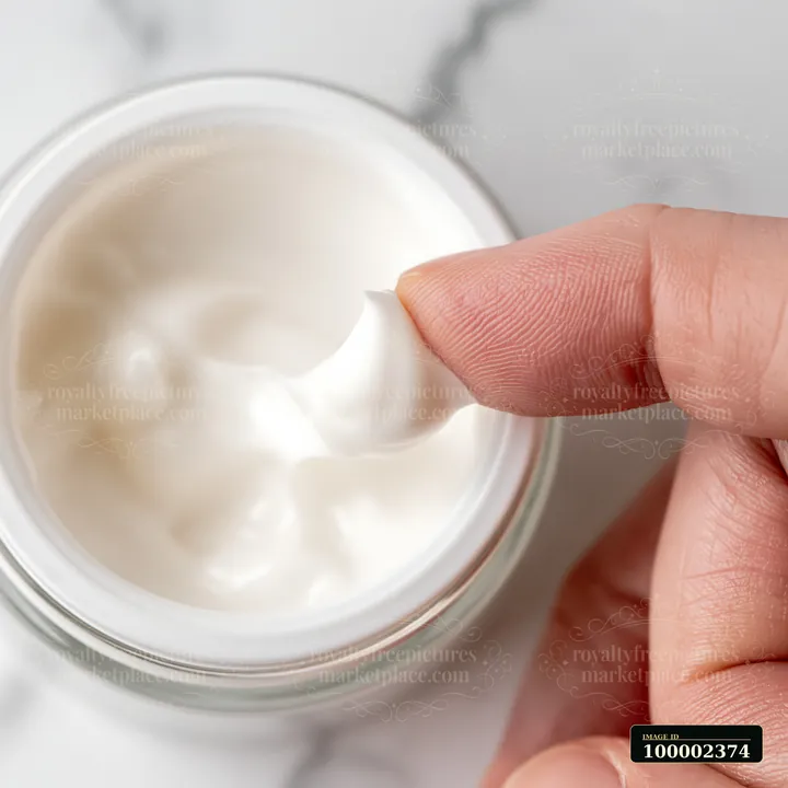 A person is shown taking a small amount of cream from a jar using a finger.