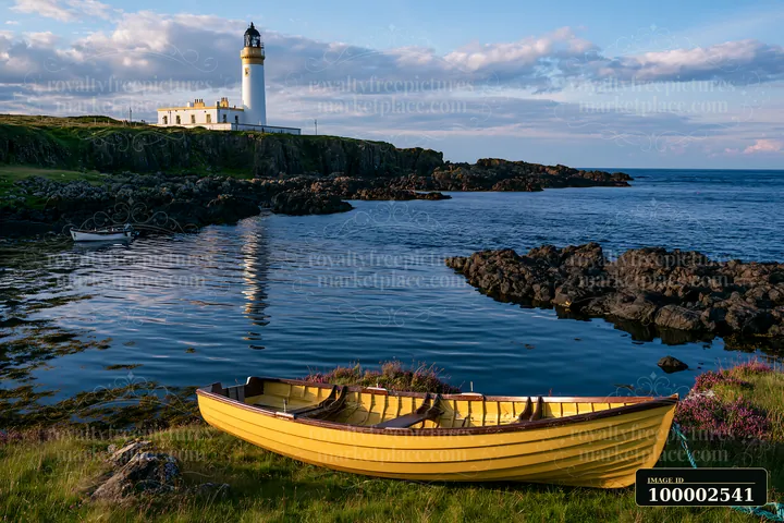 A lighthouse stands prominently by the sea with boats in the foreground.