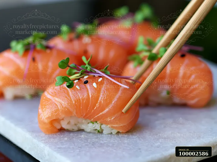 Chopsticks hold a piece of sushi garnished with microgreens.