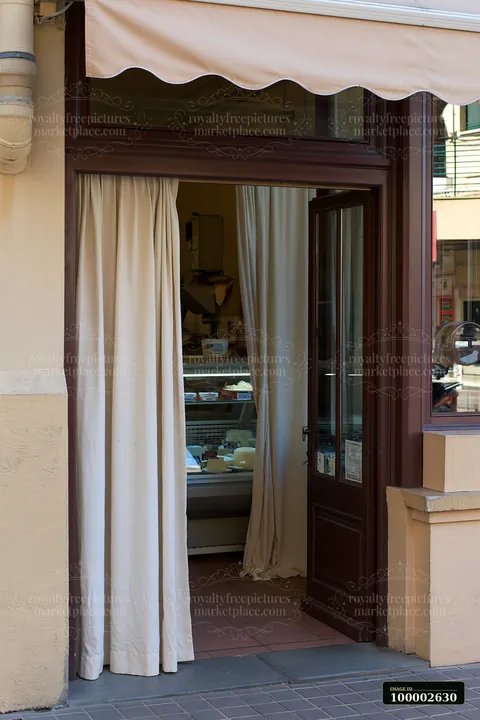 A dairy products shop on a pedestrian street has an inviting entrance with curtains.