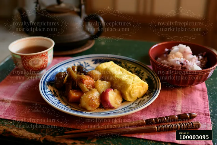A breakfast plate with Japanese breakfast includes a rolled omelet, sweet potato, and pickled vegetables.