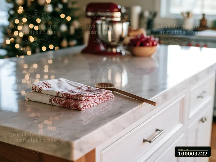 A sleek kitchen countertop features a wooden spoon and folded dish towels.