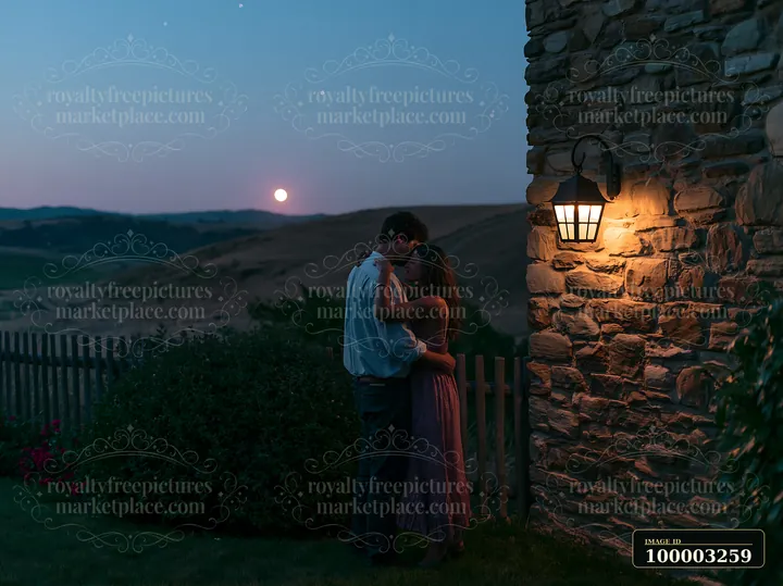 A couple dancing under stars outdoors, close to a stone building, with a lantern providing light as the moon rises over the hills in the background during twili
