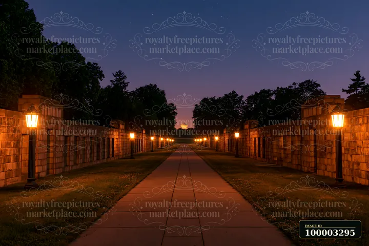 A path lined with stone walls and lanterns leads through a soldiers' cemetery at twilight.