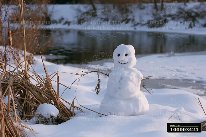A snowman surrounded by snowdrifts stands by the edge of a frozen river.
