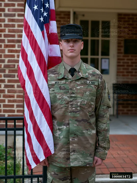 A soldier stands at attention next to the American flag by a brick building.