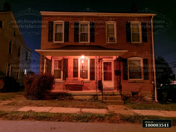 A house features a porch swing beside the front door, set against a starry night sky.
