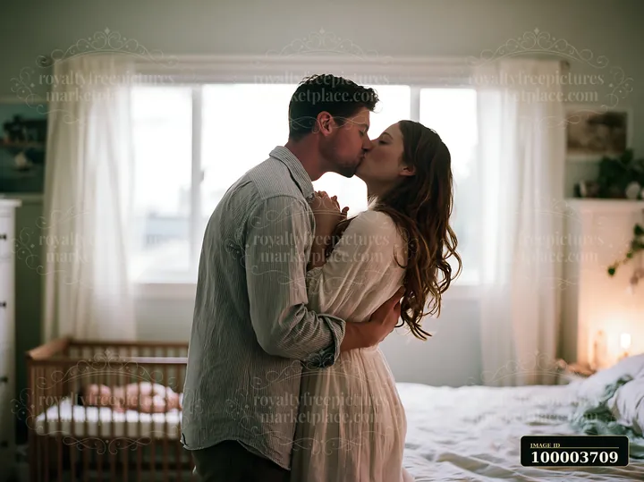 Couple kisses and embraces in a bright bedroom beside a sunlit window, with a bed and crib in the background.