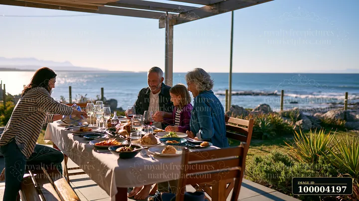 Four family members share a birthday lunch at a seaside table overlooking the ocean.